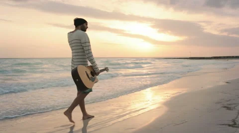 Front view of young beautiful man walk along on ocean beach seaside 動画素材 64560631