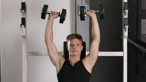 Front view of a young Caucasian bodybuilder training arm muscles by lifting Stock Footage 227363939