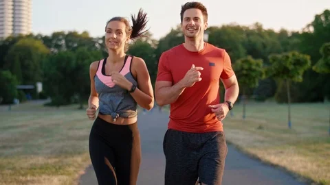 Front view of young couple jogging in the park Video stock 115831657
