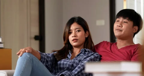 Front view, Young couple sitting front of sofa on floor and use tablet while  Stockbeeldmateriaal 198987646