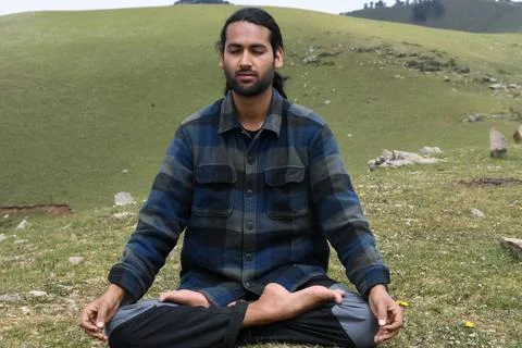 Front view of a young Indian guy practicing Meditation, Yoga in Lotus Pose  Stock Photos
