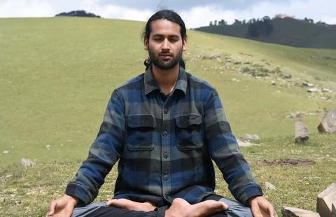 Front view of a young Indian guy practicing Meditation, Yoga in Lotus Pose Stock Photos