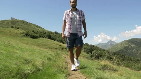 Front view of young man hiking in mountain outdoor nature scenery Vídeo Stock 64544230
