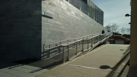 Front view of a young man in a leather jacket walking down a ramp with his la Stock Footage 122386596