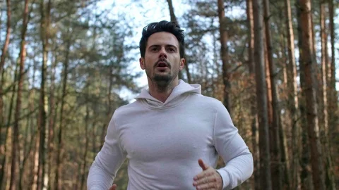 Front view of young man running in the forest Stock Footage 102823943