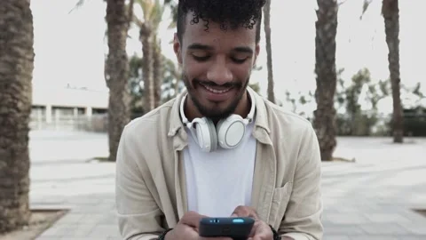 Front view of young man using cellphone outdoors Stock Footage 165521260