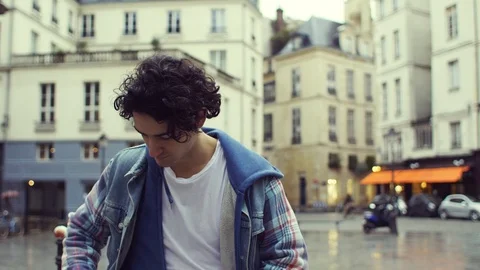 Front view of a young man walking in the streets of Paris Stock Footage 117926137