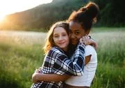 Front View Of Young Teenager Girls Friends Outdoors In Nature, Hugging. Stock Photos
