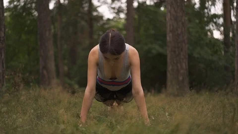 Front view of a young woman doing yoga in the forest Video stock 94971936