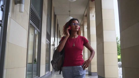 Front view of young woman using smartphone and walking in city on summer day Video stock 165193583