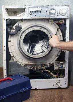 The front wall has been removed from the washing machine Stock Photos