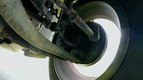 Front wheel assembly in motion under car with suspension reacting during driving Stock-Footage 347786745
