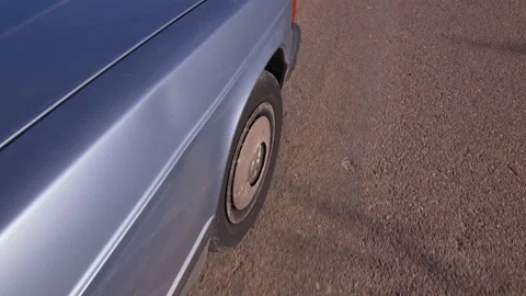 The front wheel of an old car driving on a road turns on a path, in Spain Stock Footage 208810408