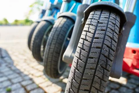 Front wheel of shared electric scooters parked in city Stock Photos