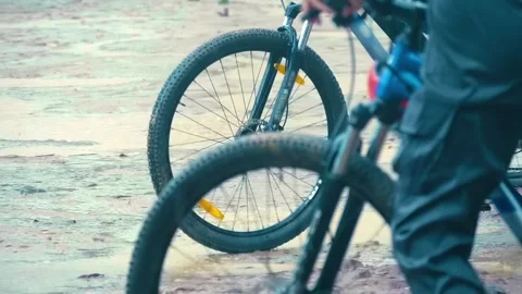 Front wheels of mountain bikes on road, on which ridden by teenagers during rain Stock Footage 305672794
