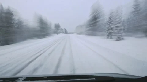Front window Point of view driving through snowy forest road during winter .. Vidéo 328371550