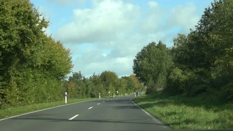 Front window view out of a black sportscar driving on a small road in a rural ar Stock Footage 141401848