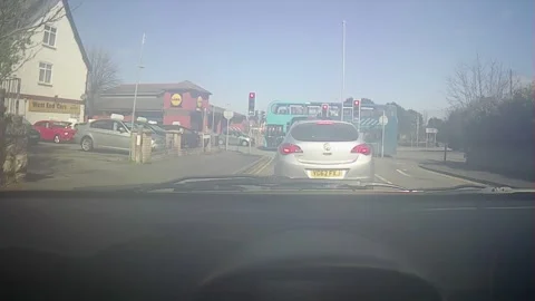Front windscreen footage stopped at a red light and then driving on green Stock Footage 247561417