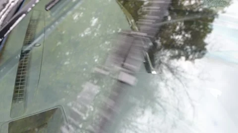 Front windshield wipers cleaning the glass, removing washer fluid and water Stock Footage 323250419