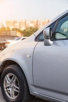 Front wing section of a silver car with wheel and side mirror of a Japanese s Stock Photos