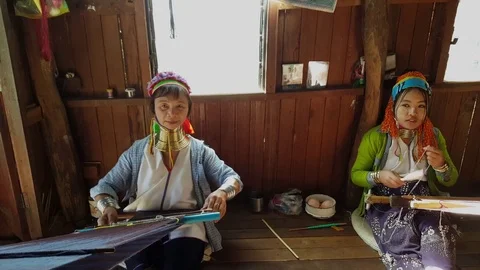 Frontal high angle shot of two Kayan long neck women weave scarves, Inle Lake Stockbeeldmateriaal 79834931