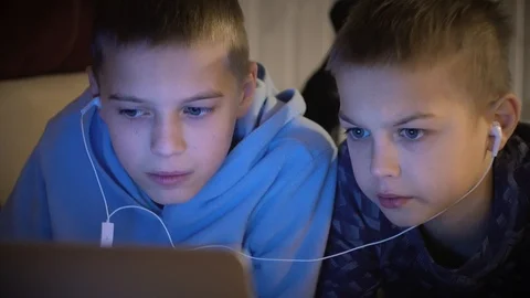 Frontal portrait of two 10 -13 years old friends or brothers watching a cartoon Stock Footage 101028762