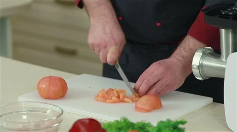 Frontal shot of chef cutting up peeled tomatoes Stock Footage 50760179