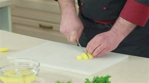 Frontal shot of chef cutting potato with a knife. Close-up Stock Footage 50757866