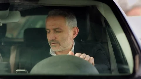 Frontal shot of a gray-haired man with a phone in his hand who gets into the Stock Footage 242609771