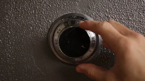 Frontal shot of a hand opening a safe combination lock dial Stock Footage 86894642