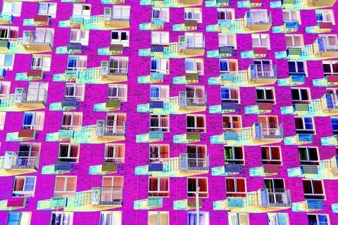 Frontal view of the facade of the building with many windows. Changed color s Ilustración de archivo