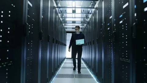 Frontal View of IT Engineer Walking Through Data Center. 動画素材 73938471