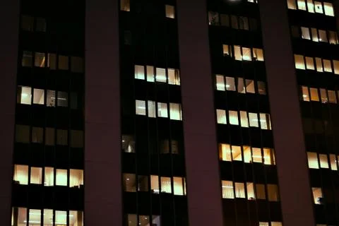 Frontal view of the night facade of building with a many windows Stock Photos