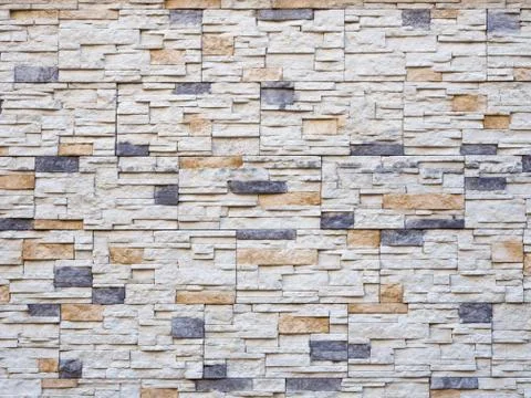 Frontal view of a wall with decorative masonry. Background texture. Full screen Stock Photos
