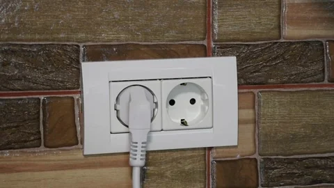 Frontal view of woman hand plugging and unplugging from the wall power 動画素材 140987635