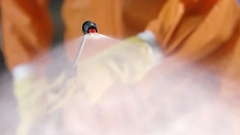 Frontline Coronavirus Worker in Full Hazmat Suit Spraying Disinfectant on Stock-Footage 129261084