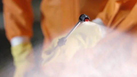Frontline Coronavirus Worker in Full Hazmat Suit Spraying Disinfectant on Stock-Footage 129261754