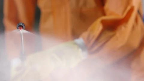 Frontline Coronavirus Worker in Full Hazmat Suit Spraying Disinfectant on Stock-Footage 129262973