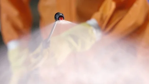 Frontline Coronavirus Worker in Full Hazmat Suit Spraying Disinfectant on Stock-Footage 129265633