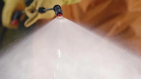Frontline Coronavirus Worker in Full Hazmat Suit Spraying Disinfectant on Stock Footage 129266850