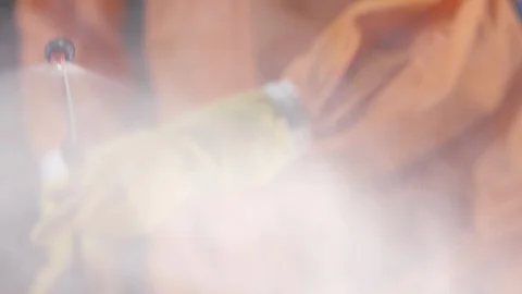 Frontline Coronavirus Worker in Full Hazmat Suit Spraying Disinfectant on Stock-Footage 129268374