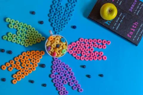 Froot loops on blue table in pattern, blue, pink, yellow and purple. Stock Photos