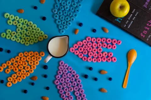 Froot loops on blue table in pattern, blue, pink, yellow and purple. Stock Photos