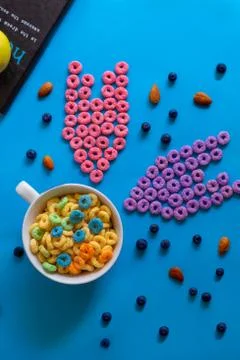 Froot loops on blue table in pattern, blue, pink, yellow and purple. Stock Photos