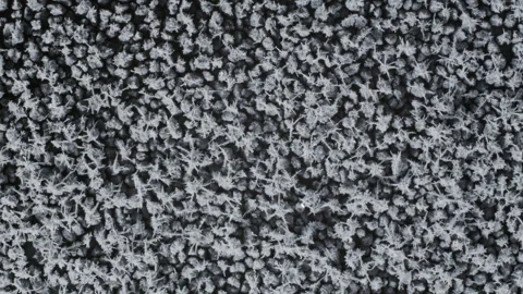 Frost and freeze, Ice and snow crystal forming on black gravel stones, 4k Stock Footage 248596185