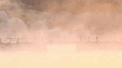 Frost and mist surround a bridge over a lake in Sweden during early morning hour Stock Footage 323070044