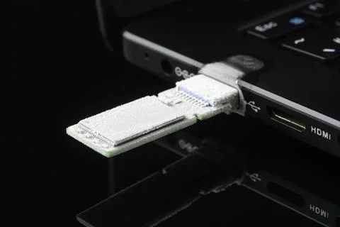 Frost covers USB flash drive in laptop port on dark background, concept of da Stock Photos