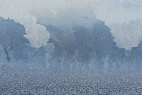 Frost forms unique patterns on window glass, showcasing nature's artistry. Th Foto stock
