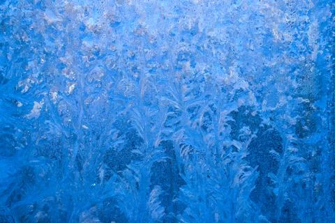 Frost pattern on a frozen window at winter. Natural background, texture Stock Photos