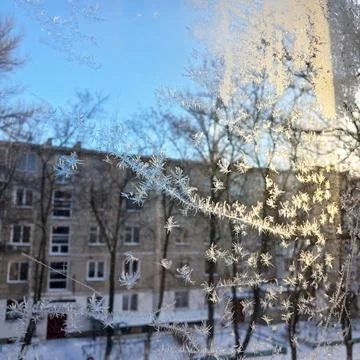 Frost pattern on window glass. ice crystals glow from the rays of the setting Foto stock